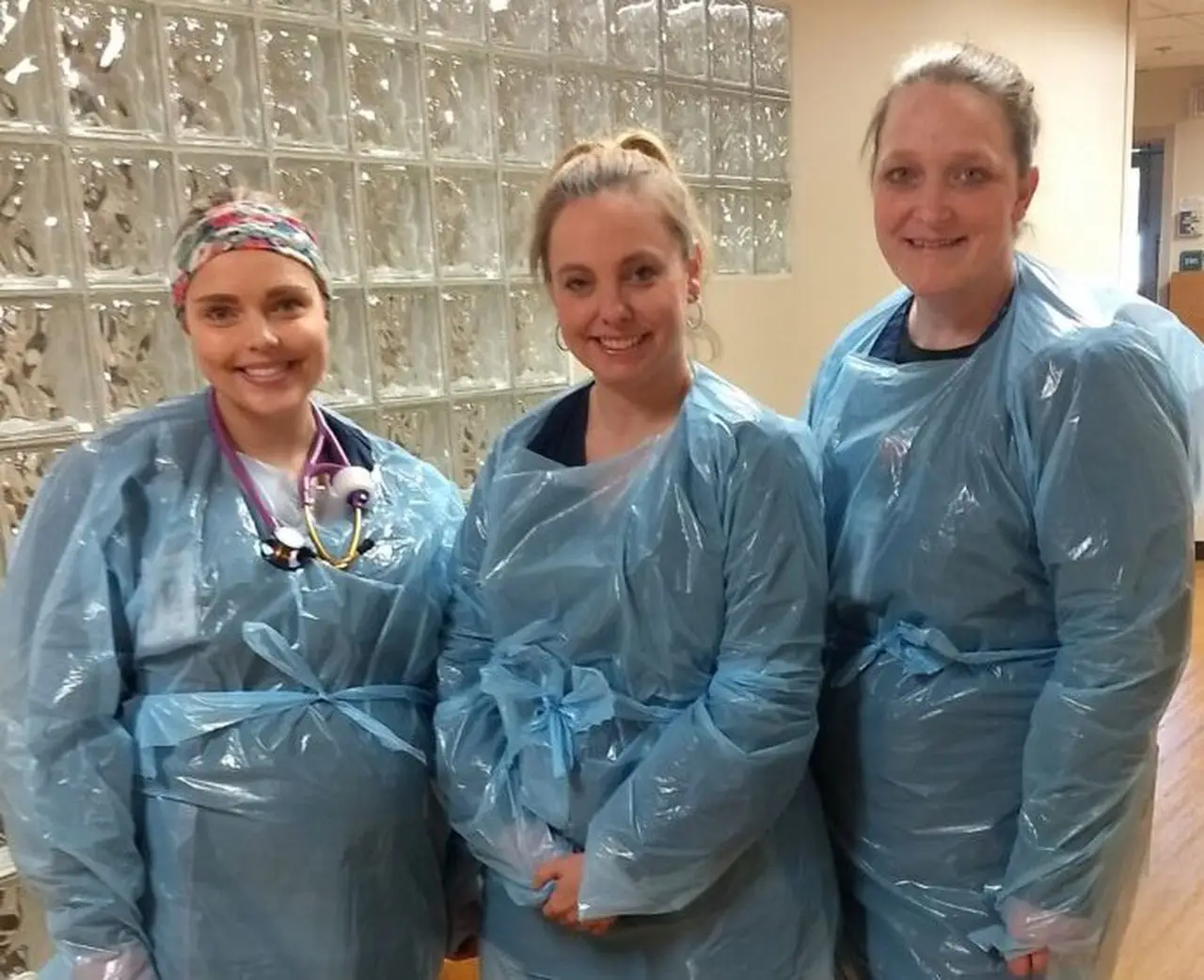Essential workers wear plastic medical gowns