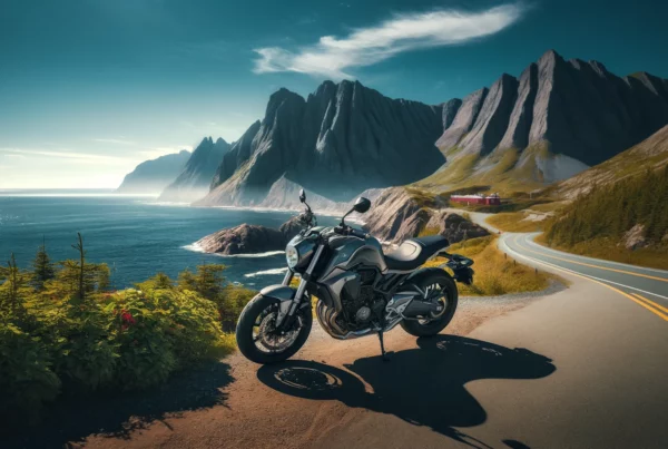 A scenic view in Newfoundland and Labrador depicting the journey to obtaining a motorcycle license NL, featuring a modern motorcycle parked on a coastal road with the ocean and rugged cliffs in the background, under a clear blue sky.